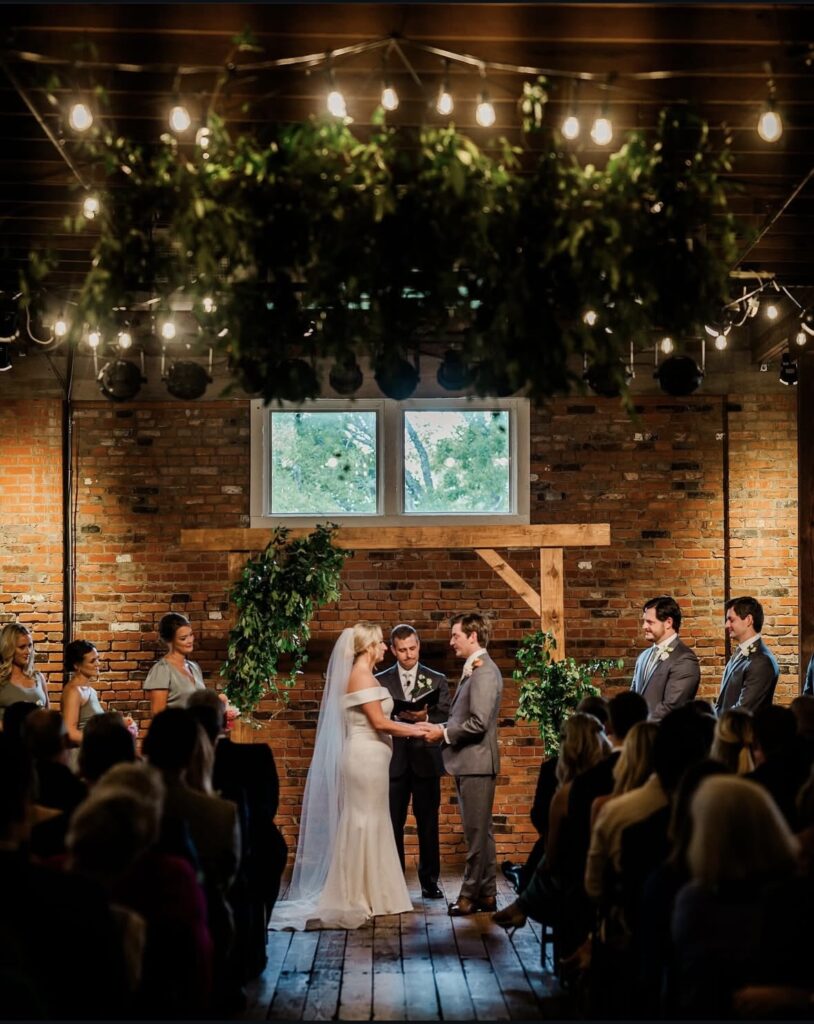 wedding ceremony with warm lighting at ice house on main bryan, tx